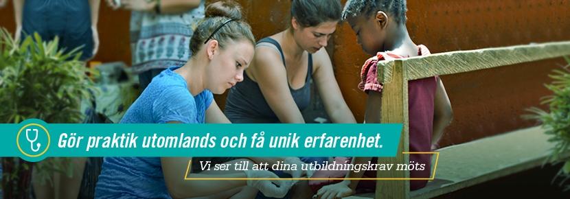 Gör praktik utomlands inom folkhälsa och få praktisk erfarenhet Kvinnlig volontär vi folkhälsoprojekt i Ghana lägger om ett sår på en liten flickas knä