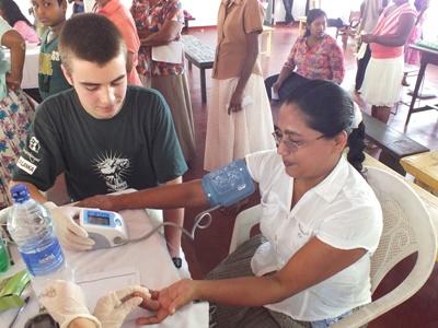 Interning on the Medicine Project with Projects Abroad Medicine intern checking the blood pressure of a woman
