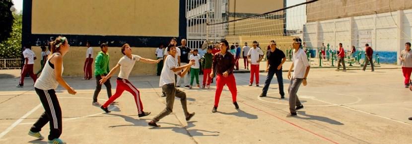 Volunteers Coach Volleyball with Children Abroad Volunteer in a volleyball training session with students overseas with Projects Abroad